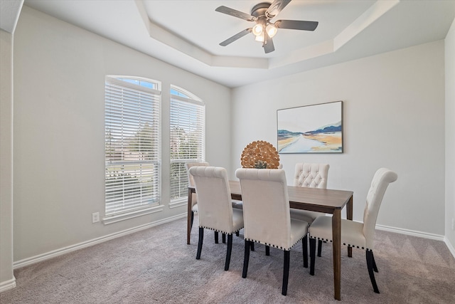 carpeted dining area featuring ceiling fan and a tray ceiling