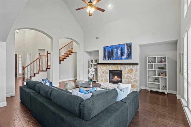 living room with ceiling fan, high vaulted ceiling, a fireplace, and dark hardwood / wood-style flooring