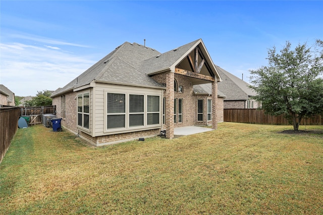 rear view of property with a patio and a lawn