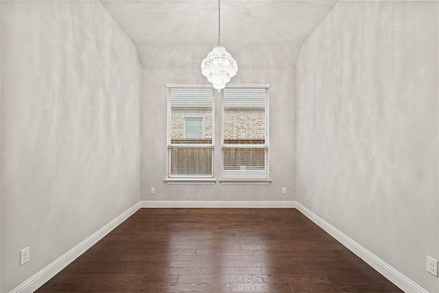 unfurnished room featuring a notable chandelier and dark hardwood / wood-style floors