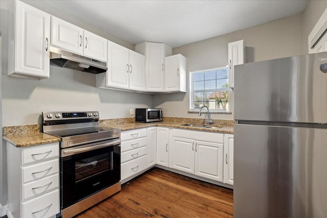 kitchen featuring dark wood-type flooring, sink, white cabinets, appliances with stainless steel finishes, and light stone counters