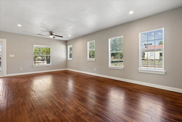 empty room featuring a textured ceiling, dark hardwood / wood-style floors, and ceiling fan