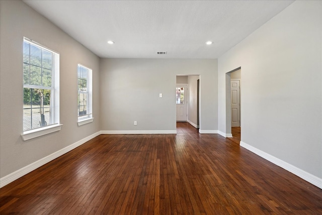 unfurnished room with plenty of natural light and dark hardwood / wood-style flooring