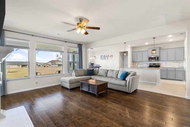 living room with ceiling fan and dark hardwood / wood-style flooring