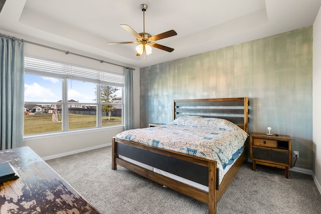 bedroom featuring carpet, ceiling fan, and a tray ceiling