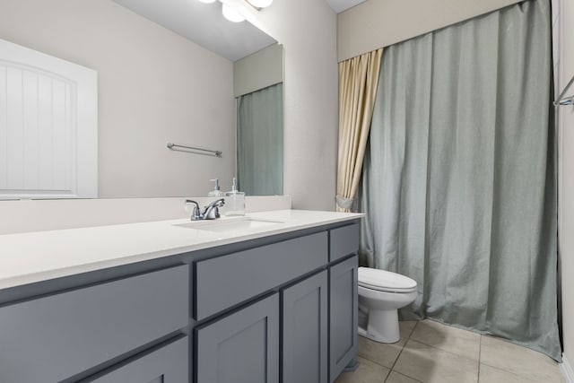 bathroom with toilet, vanity, and tile patterned floors