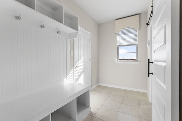 mudroom featuring a barn door and light tile patterned floors