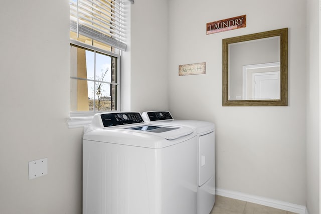 clothes washing area with light tile patterned floors and washer and clothes dryer