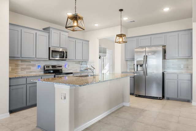 kitchen featuring pendant lighting, stainless steel appliances, sink, and tasteful backsplash