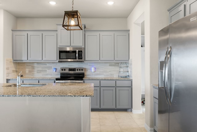 kitchen featuring tasteful backsplash, appliances with stainless steel finishes, sink, and hanging light fixtures