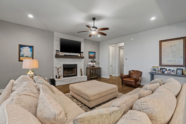 living room featuring a fireplace, ceiling fan, and wood-type flooring