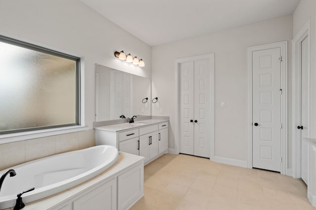 bathroom featuring tile patterned floors, a tub, and vanity