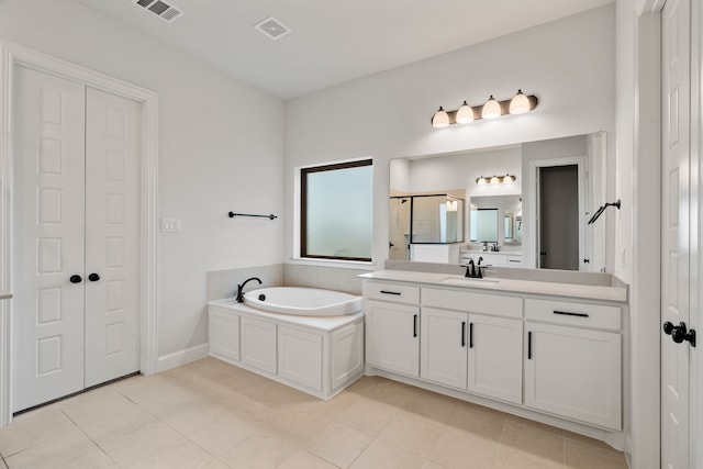 bathroom with shower with separate bathtub, vanity, and tile patterned flooring