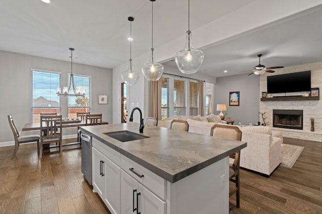 kitchen featuring sink, white cabinetry, a kitchen island with sink, and pendant lighting