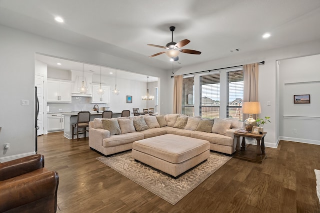 living room with sink, dark hardwood / wood-style flooring, and ceiling fan with notable chandelier