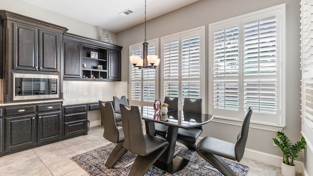 tiled dining area featuring plenty of natural light and a notable chandelier