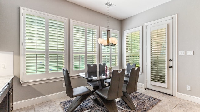 tiled dining room with an inviting chandelier