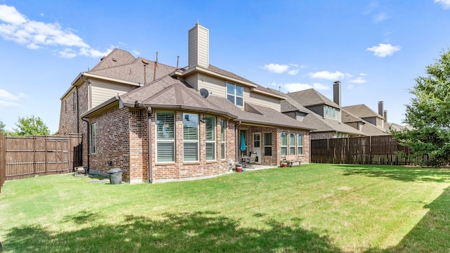 rear view of house with a patio and a yard