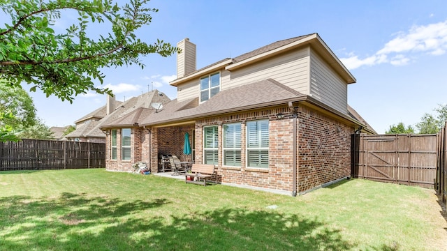 back of house with a patio and a yard