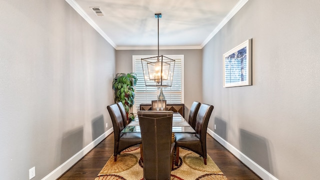 dining space with dark wood-type flooring, a chandelier, and ornamental molding