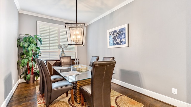 dining area featuring ornamental molding, dark hardwood / wood-style flooring, and a chandelier