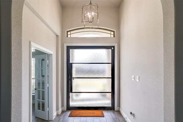 doorway to outside featuring a chandelier