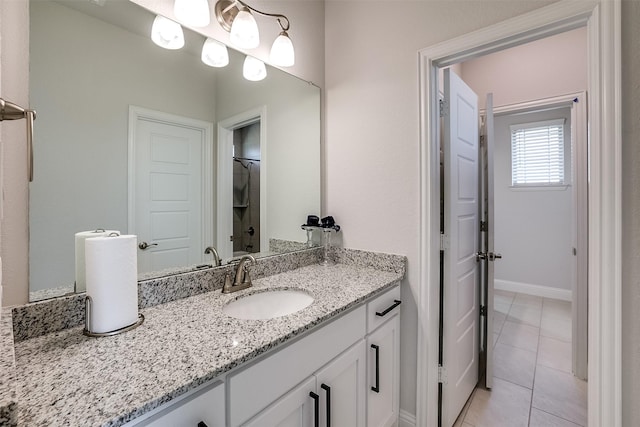 bathroom featuring tile patterned flooring, vanity, and baseboards