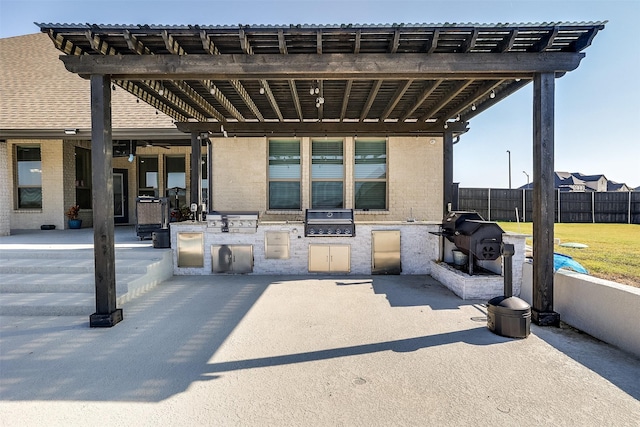 view of patio featuring exterior kitchen, grilling area, fence, and a pergola