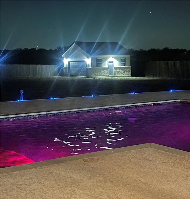 view of pool at twilight