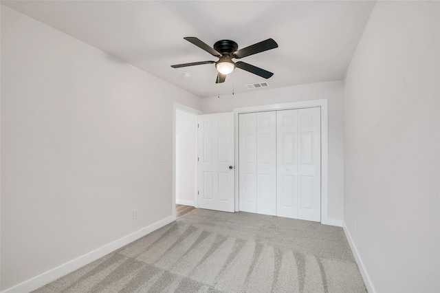 unfurnished bedroom with carpet, ceiling fan, and a closet