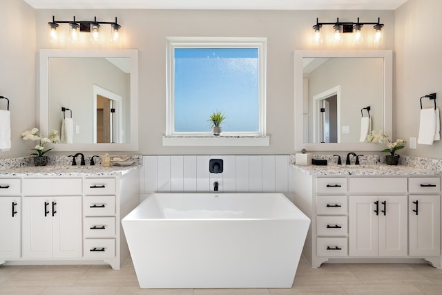 bathroom with vanity, a tub, and tile patterned flooring