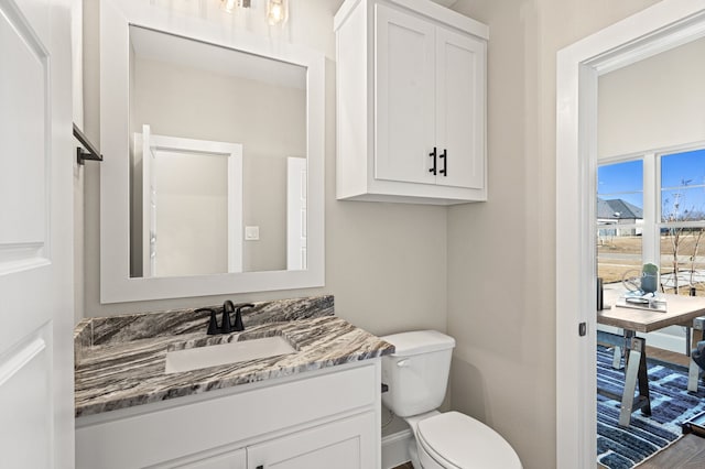 bathroom with vanity, toilet, and hardwood / wood-style flooring