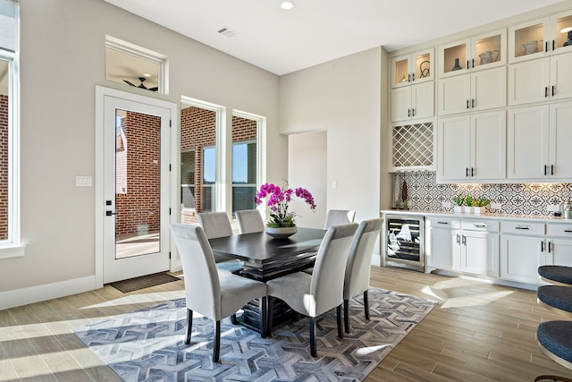 dining room with light wood-type flooring and beverage cooler