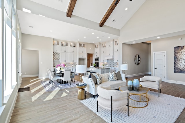 living room featuring light hardwood / wood-style floors, beam ceiling, and high vaulted ceiling