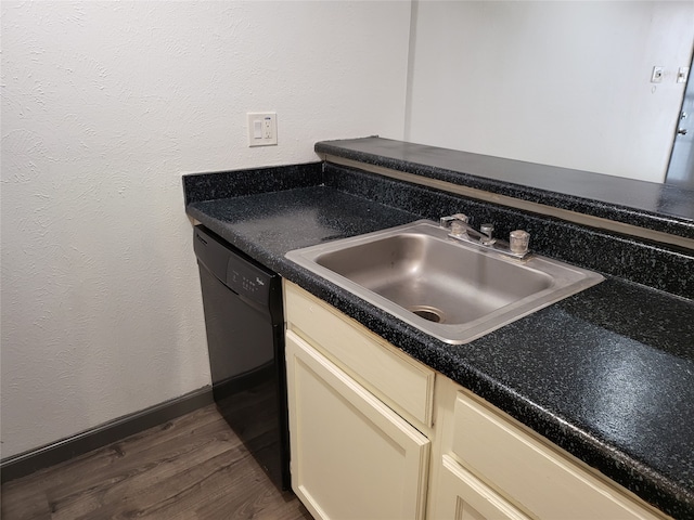 kitchen featuring dishwasher, sink, dark wood-type flooring, and cream cabinetry