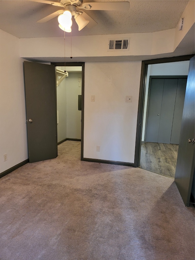 carpeted spare room with a textured ceiling and ceiling fan