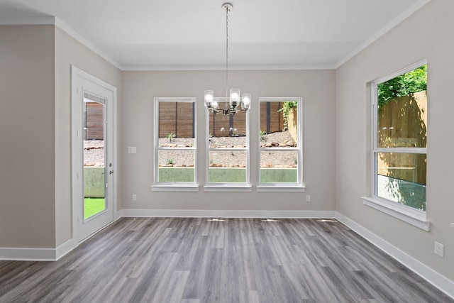 unfurnished dining area with ornamental molding, wood-type flooring, and a notable chandelier