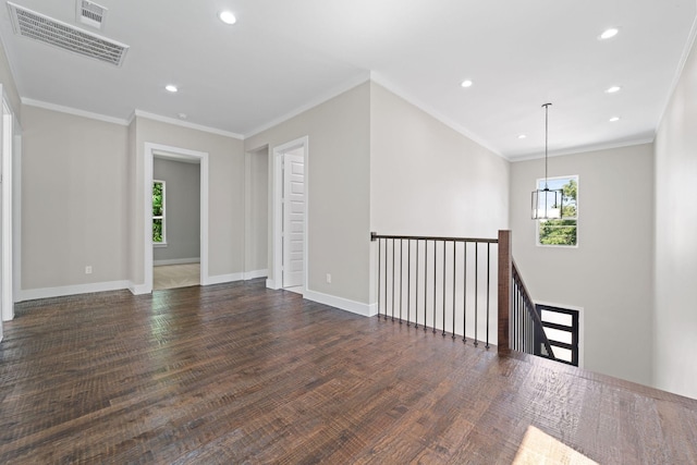 spare room featuring ornamental molding and dark hardwood / wood-style floors