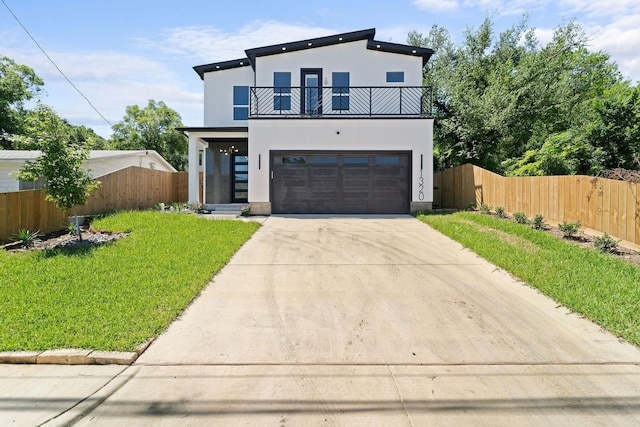 view of front of home with a garage, a balcony, and a front lawn