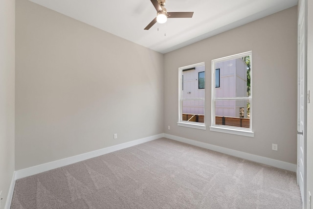 carpeted spare room featuring ceiling fan