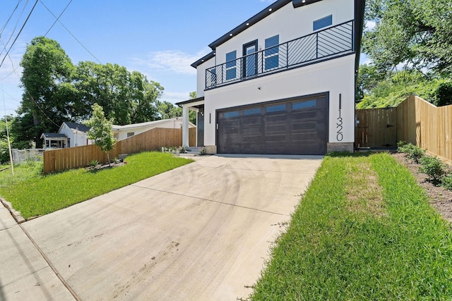 contemporary home featuring a garage, a balcony, and a front lawn