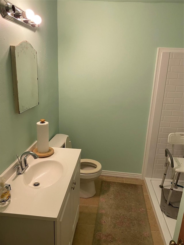 bathroom featuring tile patterned flooring, vanity, toilet, and walk in shower