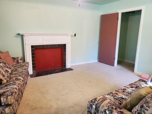 living room with carpet flooring and a tiled fireplace