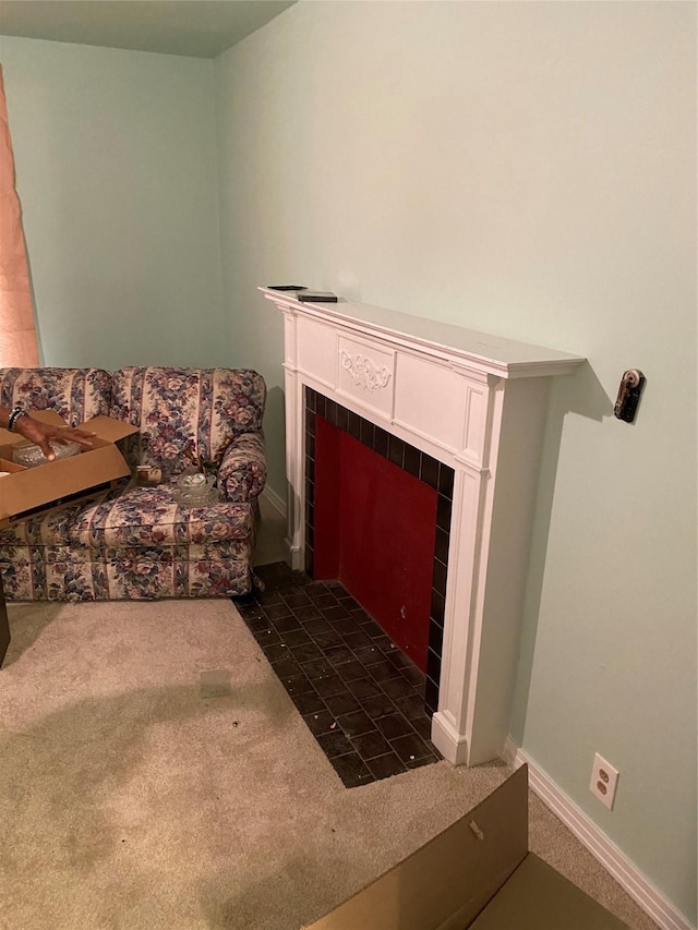 carpeted living room with a tile fireplace