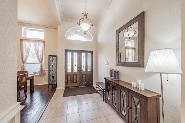 foyer with light hardwood / wood-style flooring and ornamental molding