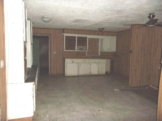 basement with wooden walls and a textured ceiling