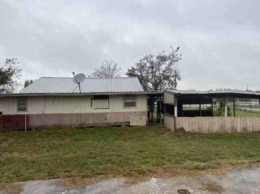 view of side of home with a yard