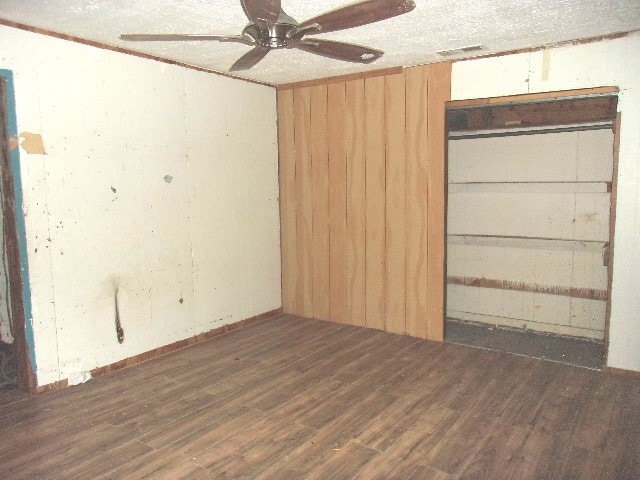 unfurnished room with ceiling fan, dark hardwood / wood-style floors, and a textured ceiling