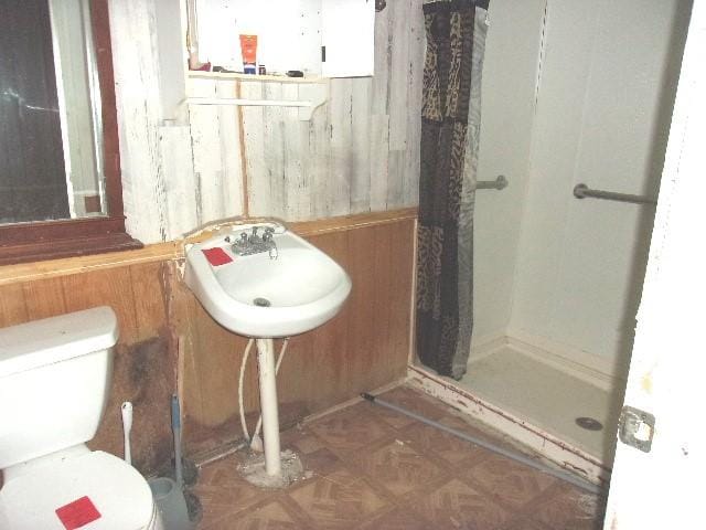 11114 E State Highway 31, Kerens, TX 75144 - full bathroom featuring a stall shower, toilet, and wood walls