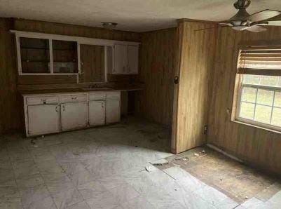 11114 E State Highway 31, Kerens, TX 75144 - kitchen featuring wood walls, a ceiling fan, and light flooring